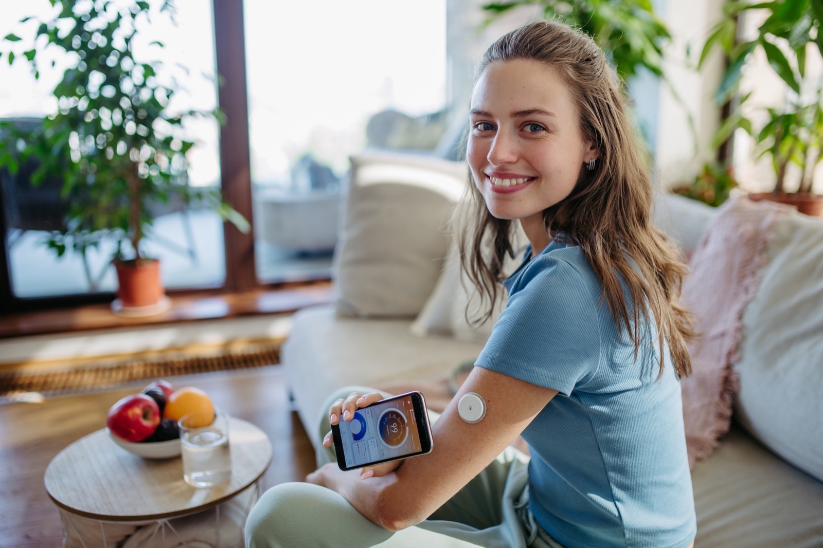 Young woman with continuous glucose monitor managing her diabetes